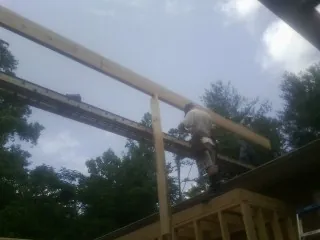 Carpenter setting a ridge beam over a new addition frame — Ice Dam Removal by Roofing Brothers in South Berwick