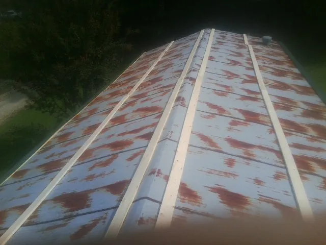Rusted metal roof panels with new wood purlins before replacement — Storm Damage Roof Repair in South Berwick by Roofing Brothers
