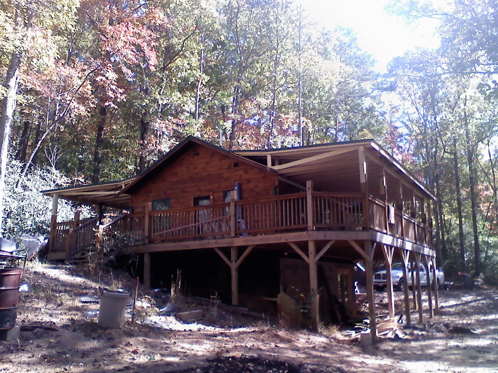 Log cabin with a wraparound porch and metal roof in the fall in South Berwick