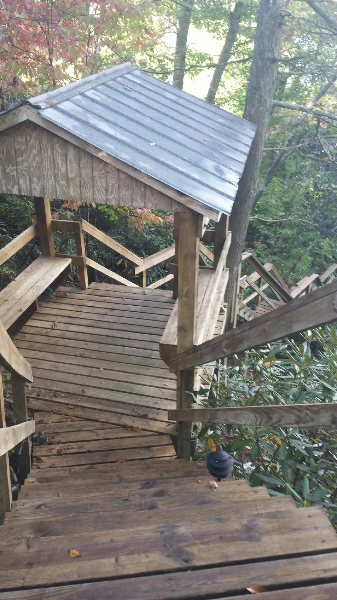 Metal roofed shelter over wooden steps on a wooded walkway — Skylight Repair & Installation work by our crew in South Berwick