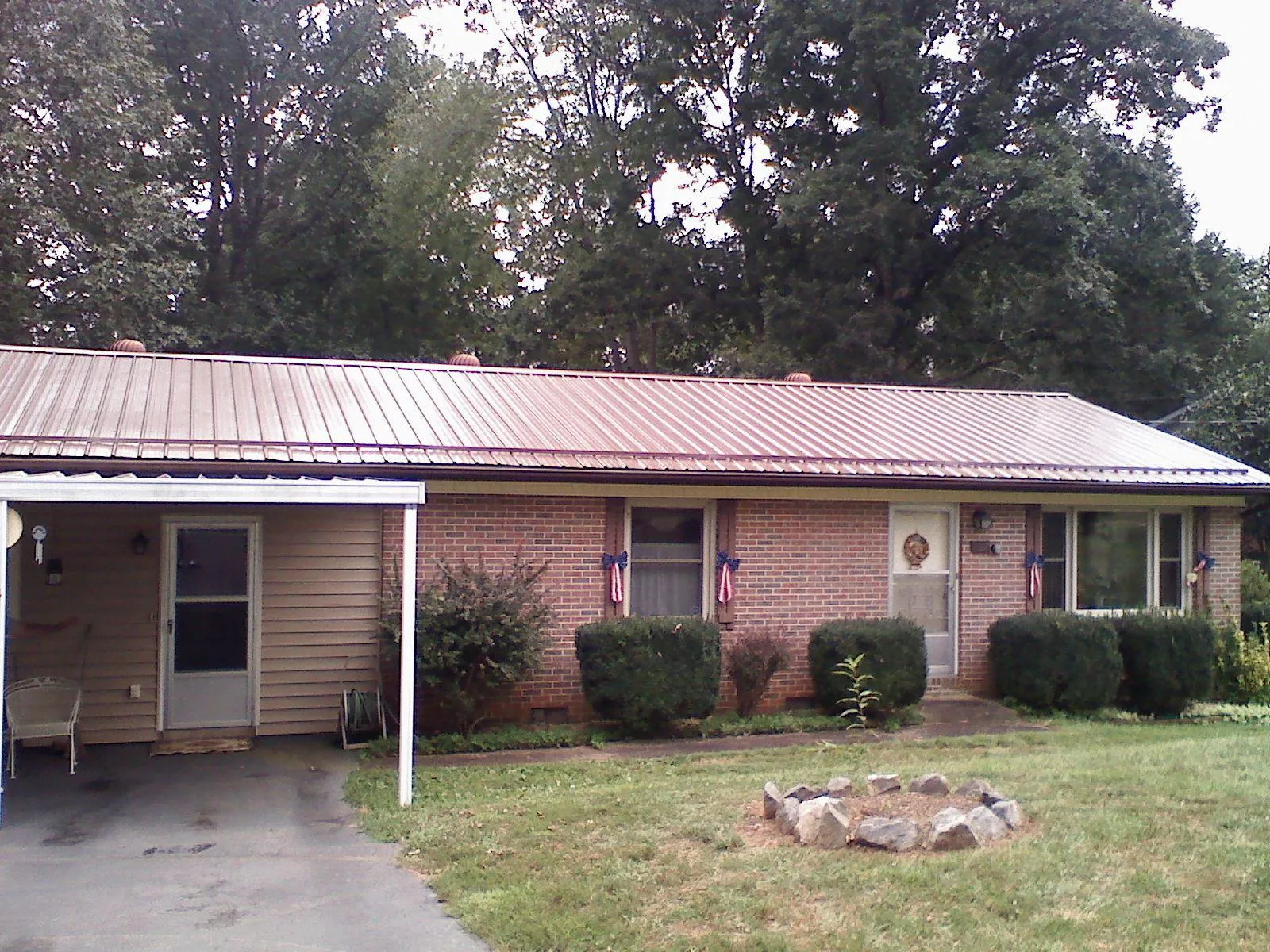 Bronze metal roof and carport on a brick ranch home — Roof Repair work by our crew in South Berwick